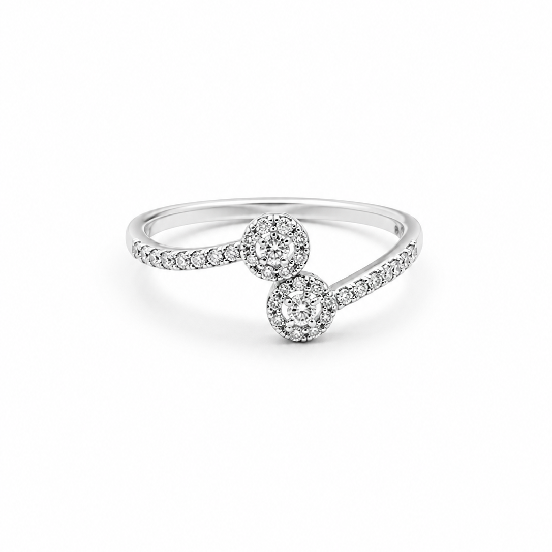 A silver-toned diamond ring featuring two round diamond clusters connected by a pavé-set band, shown on a clean white background.