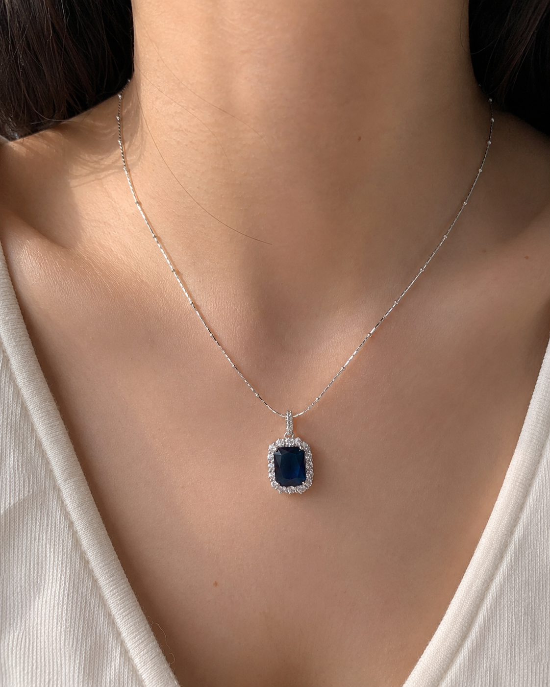 Necklace with a blue pendant worn by a person