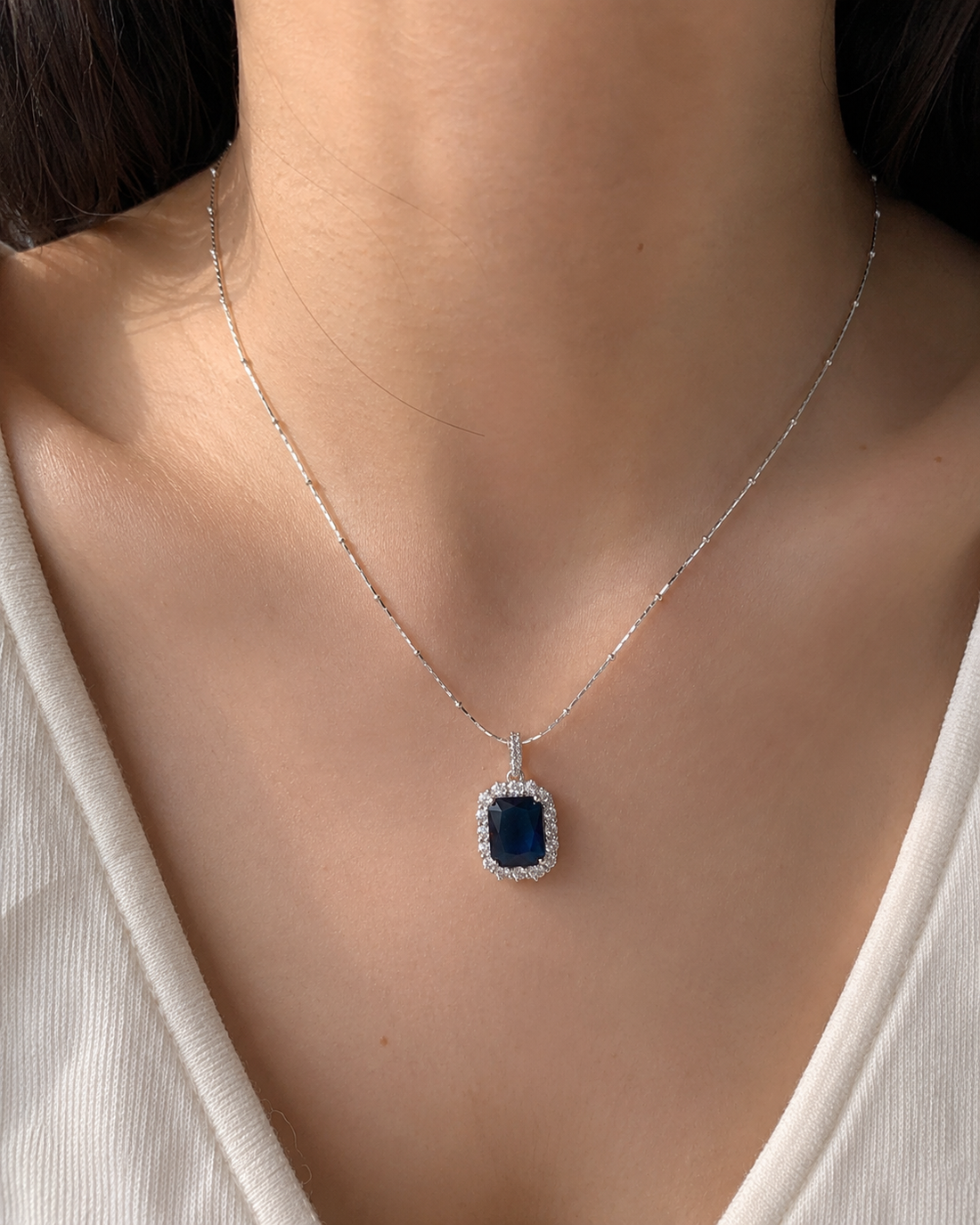 Necklace with a blue pendant worn by a person