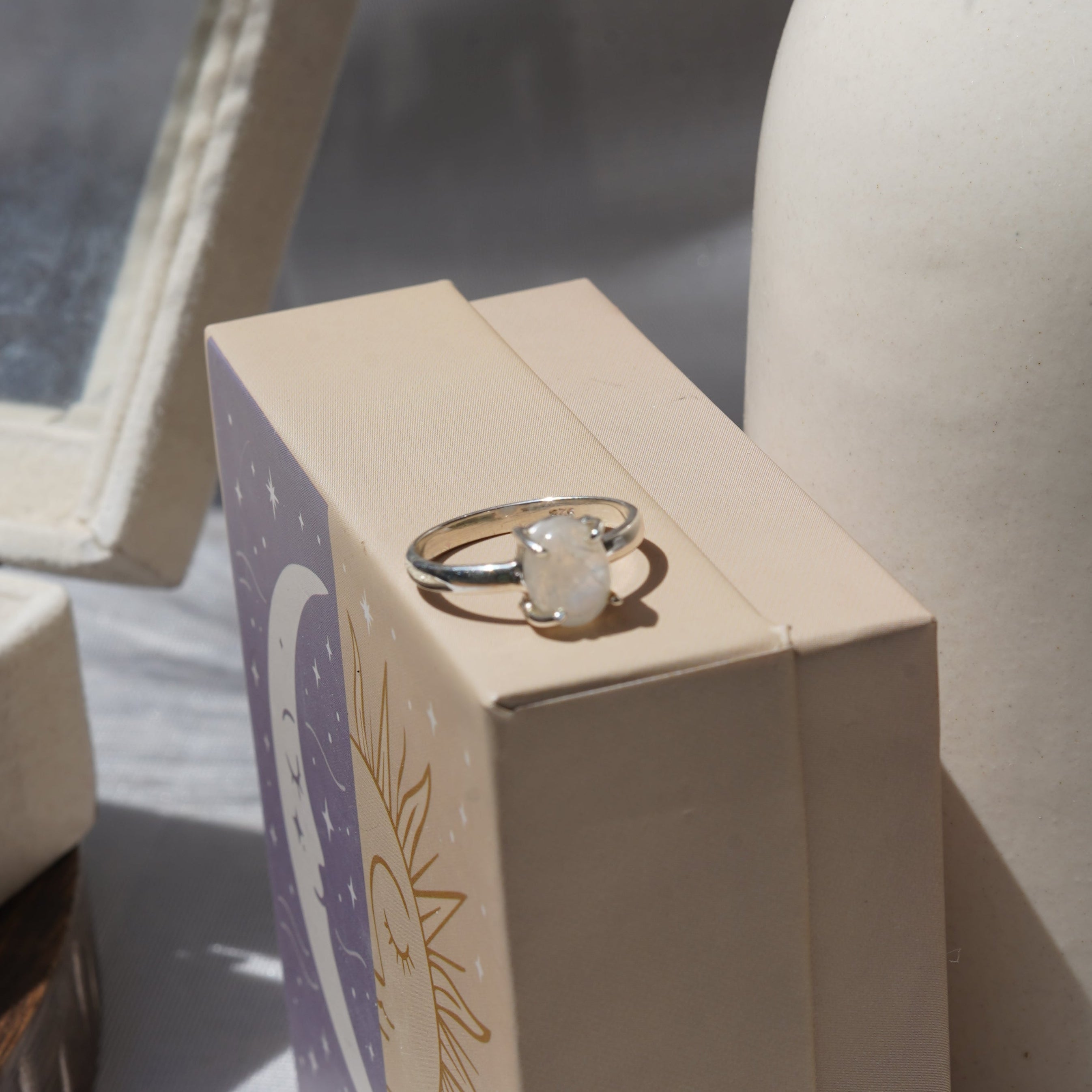 Gold ring inside an open jewelry box on a textured surface