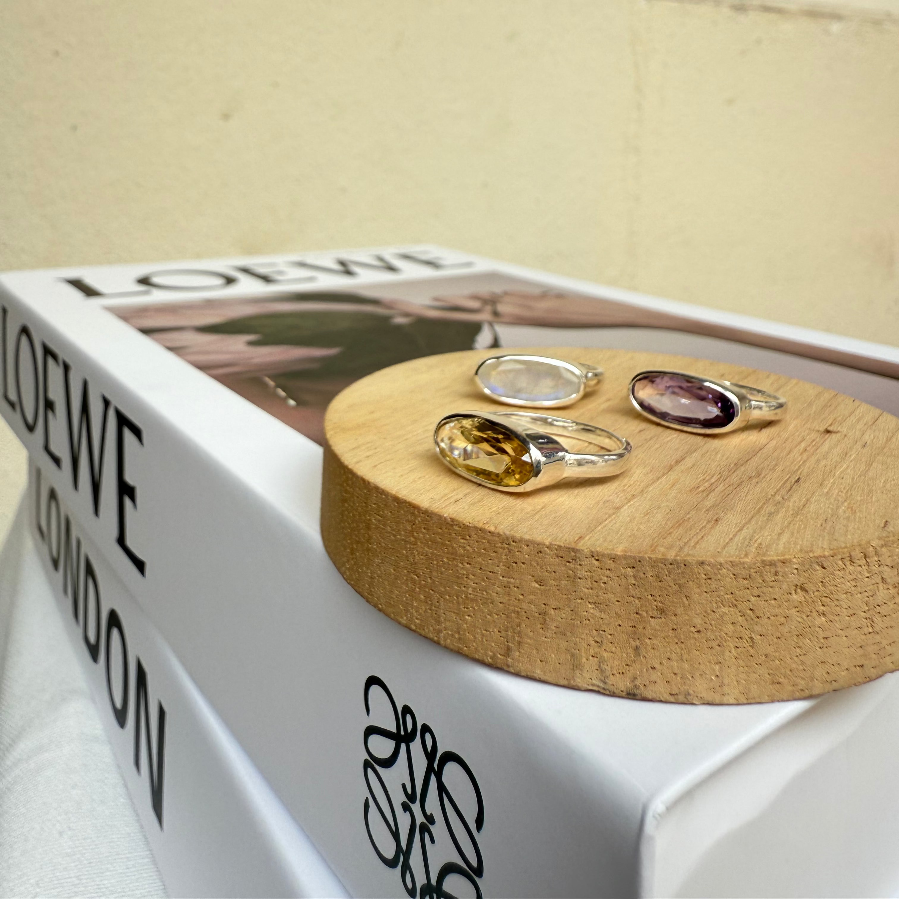 Two rings on a wooden stand with a Loewe box in the background