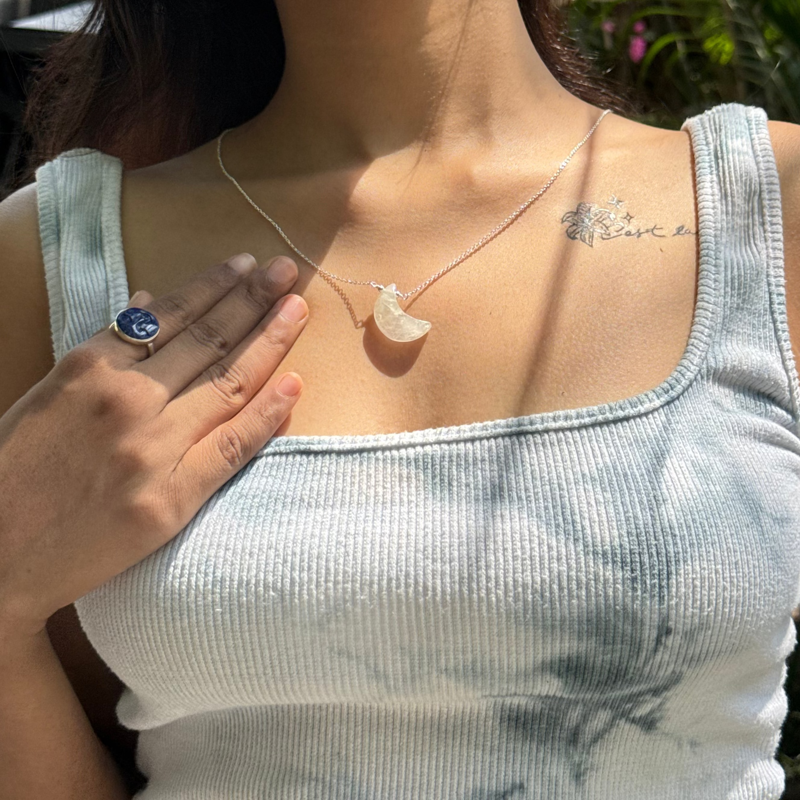 Woman wearing a necklace with a moon design outdoors