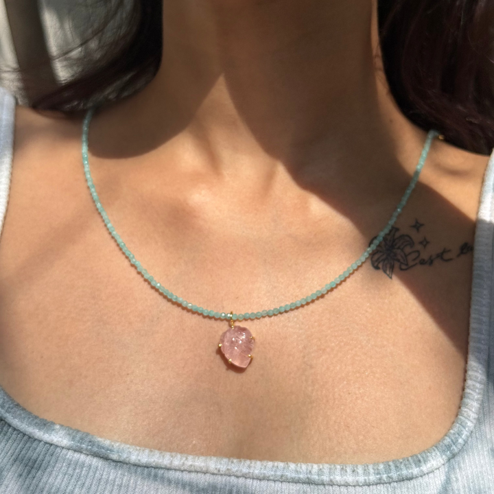 Necklace with a pink pendant worn by a person