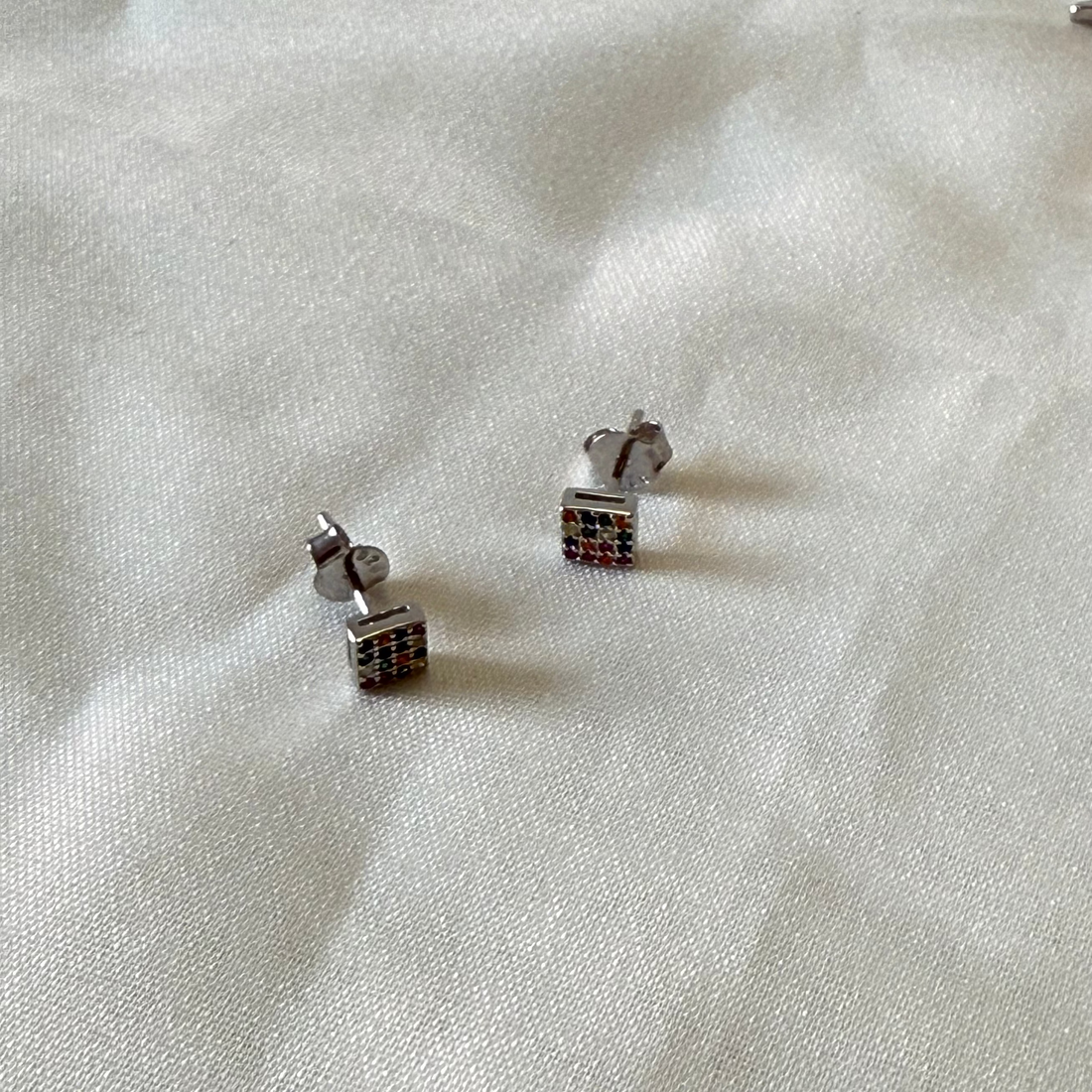 Pair of silver earrings on a white fabric background