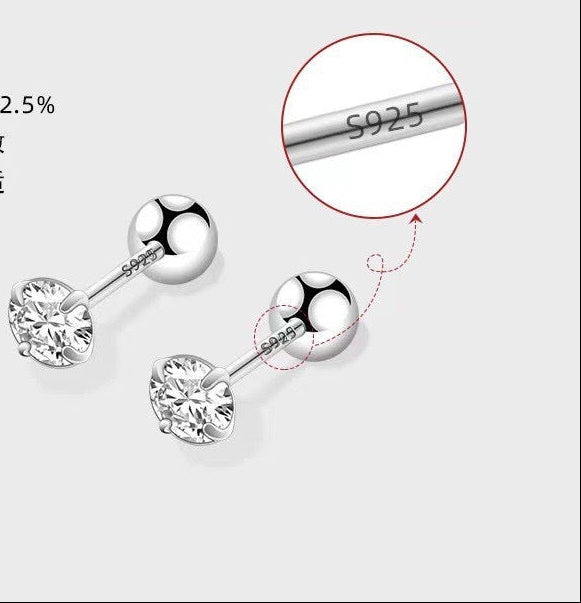 Silver earrings with a close-up of '925' stamp on a light gray background