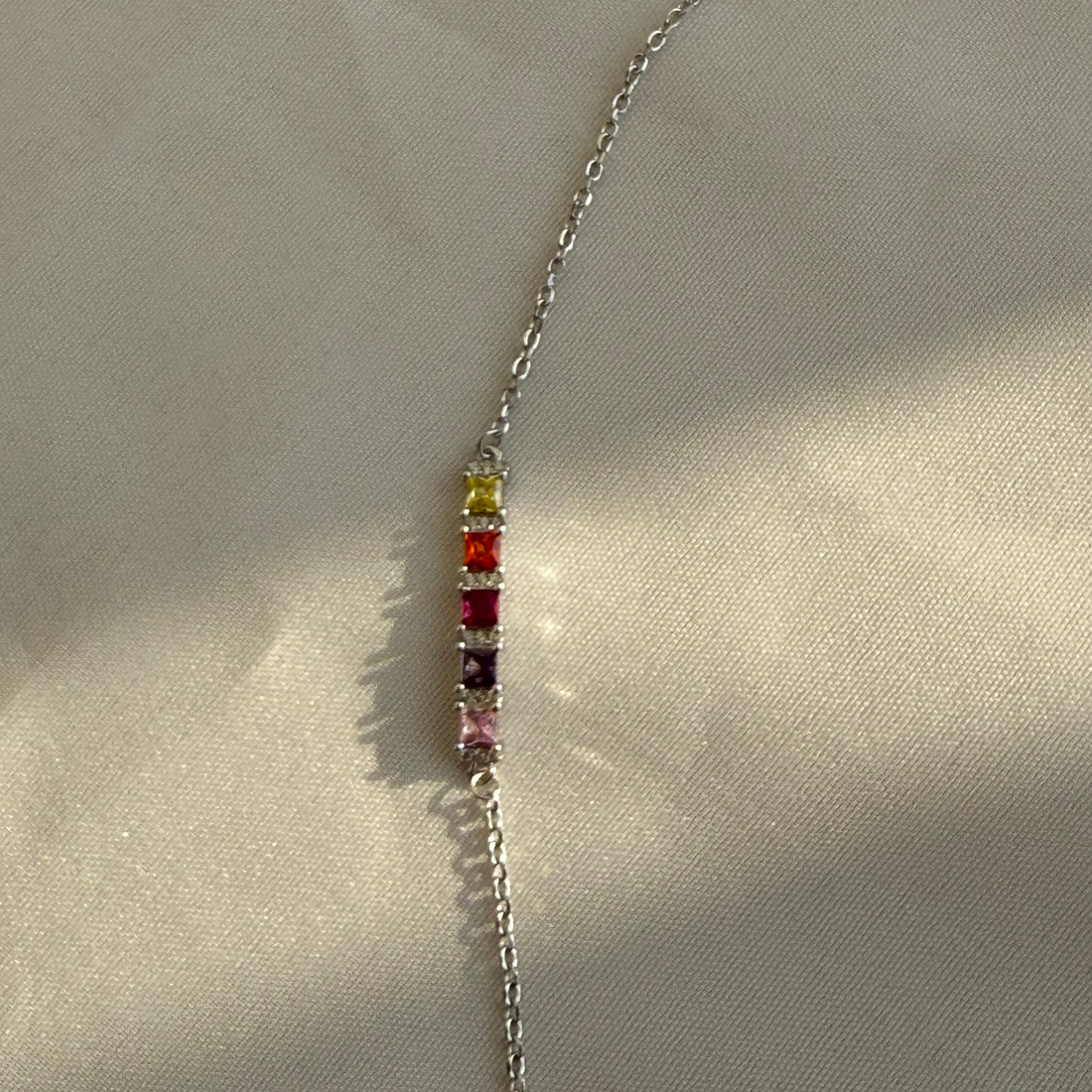 Bracelet with colorful beads on a beige fabric background