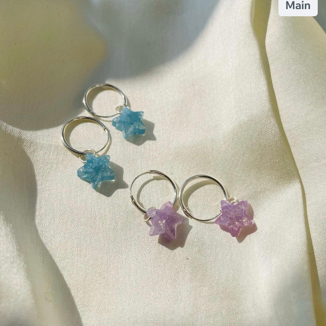 Star-shaped earrings on a light fabric background