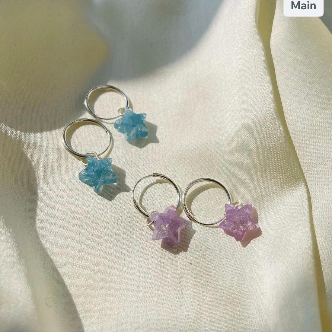 Star-shaped earrings on a light fabric background