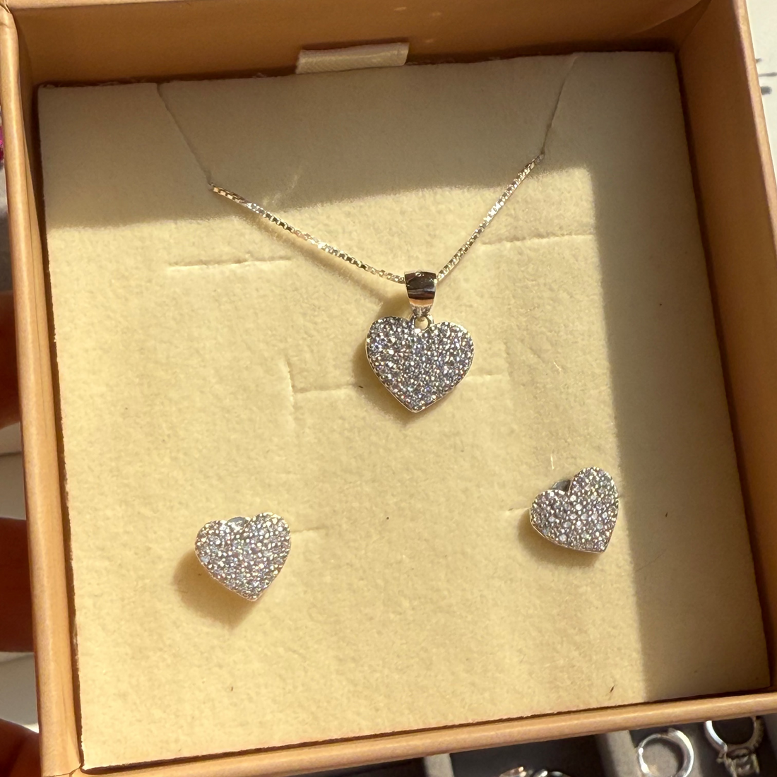 Heart-shaped jewelry set in a box with a beige interior