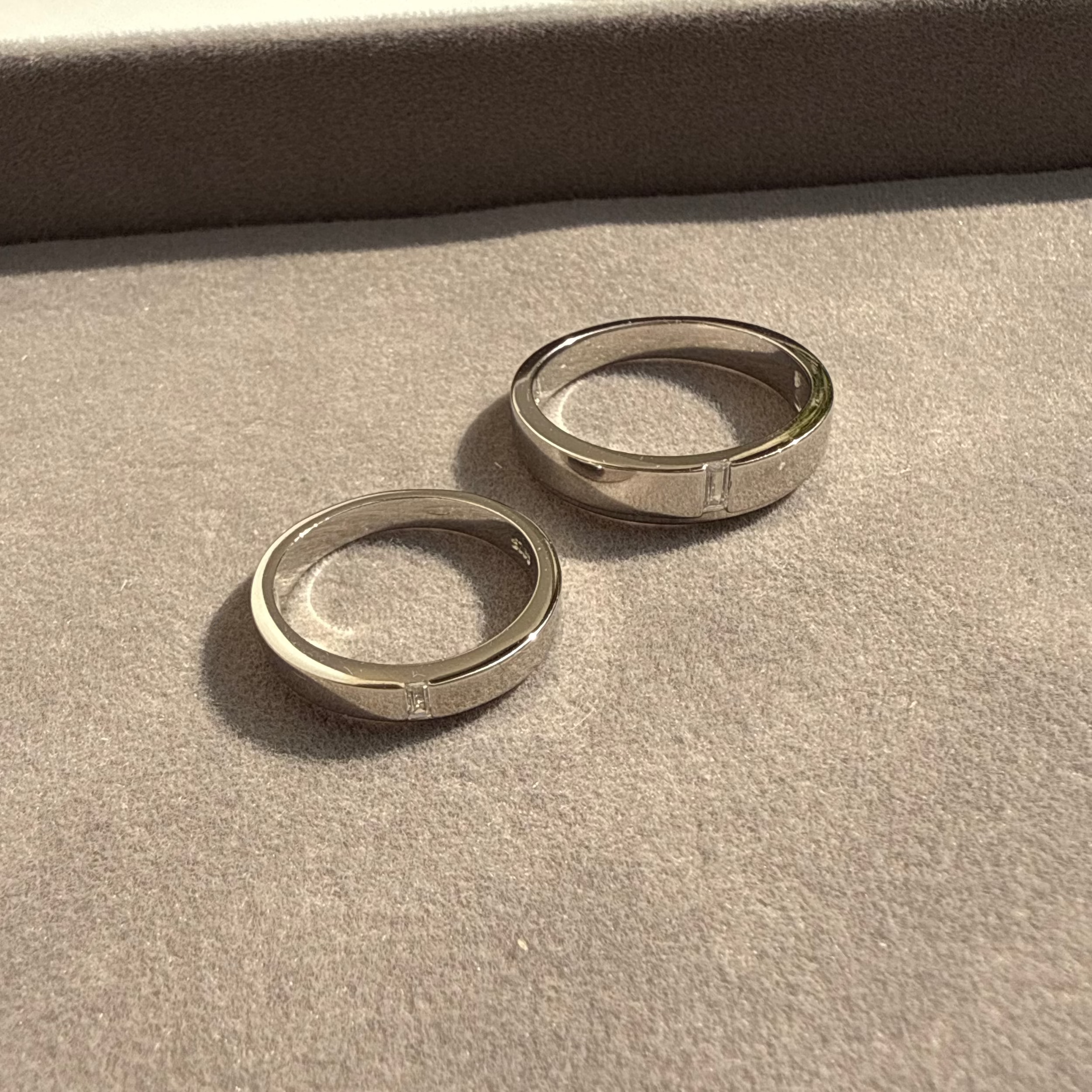 Two silver rings on a textured surface with a blurred background