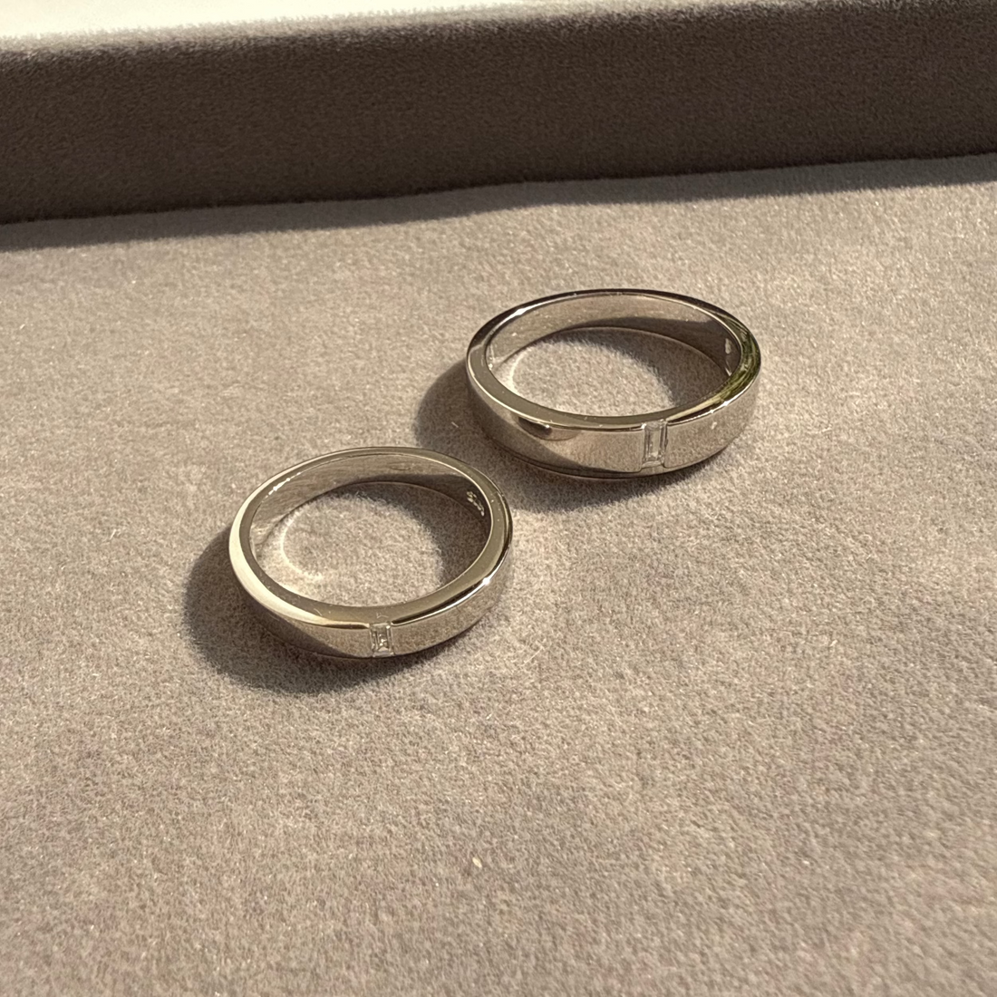Two silver rings on a textured surface with a blurred background