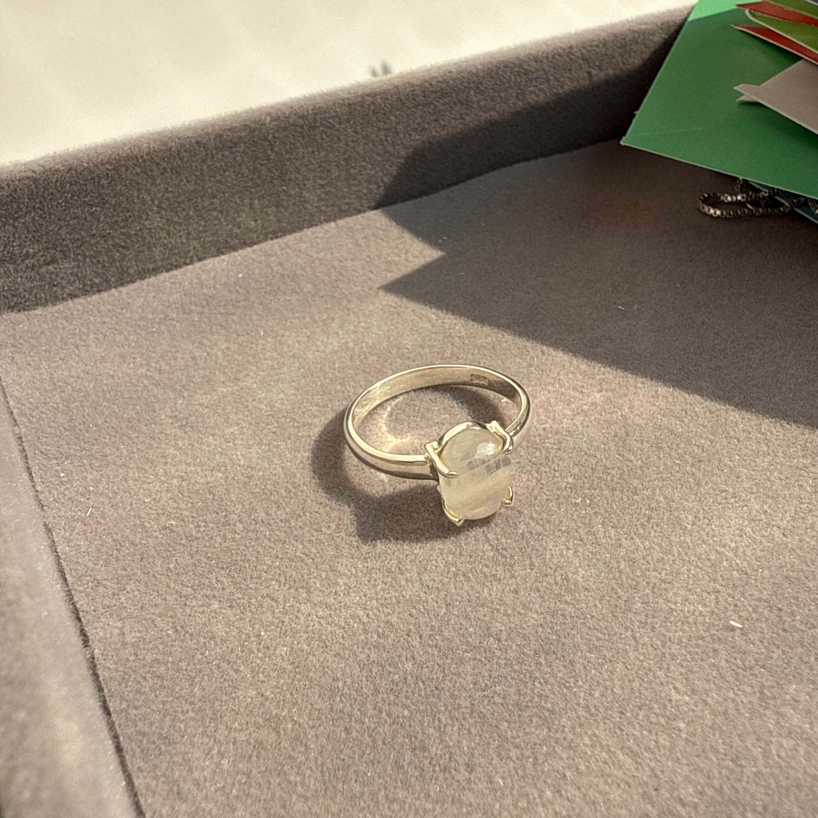 Silver ring with a clear gemstone on a textured surface