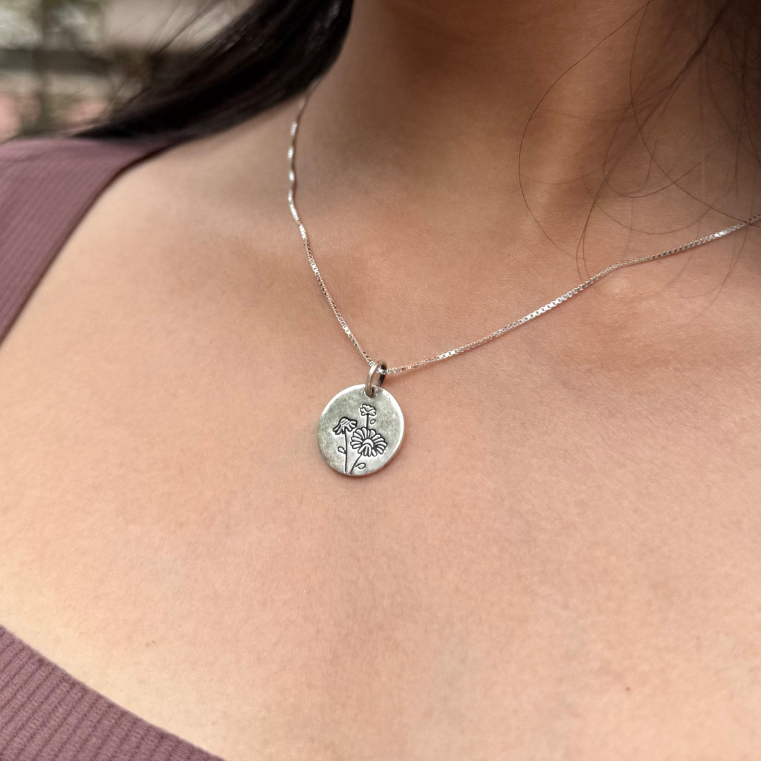 Woman wearing a necklace with a pendant outdoors